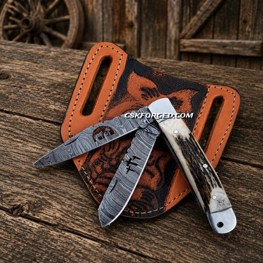 Cowboy folding trapper knife with Damascus steel double blades and stag horn handle and pancake sheath.